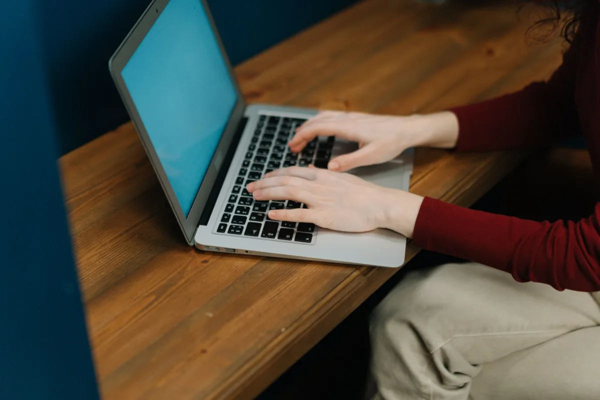 Ahşap masada açık duran bilgisayar ve eski MacBook ne zaman satılmalı sorusu